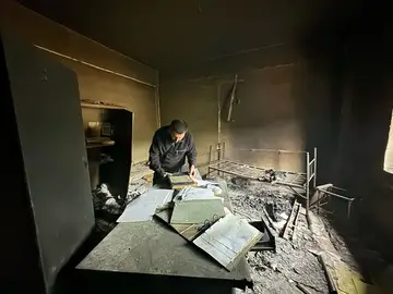 Preserving records inside a burned archive room at a former Assad detention site