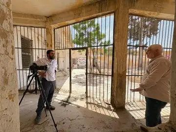 Recording a witness testimony beside barred corridors at a former detention site