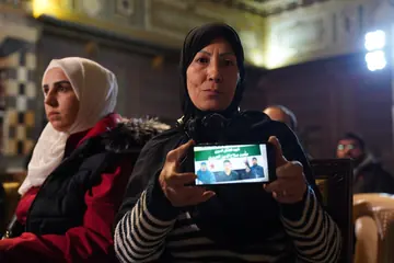 A participant at the Branch 215 event holding a phone with information about a missing person