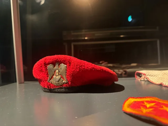 A Syrian military-police cap and insignia displayed among objects in the Sednaya exhibition in Hanover