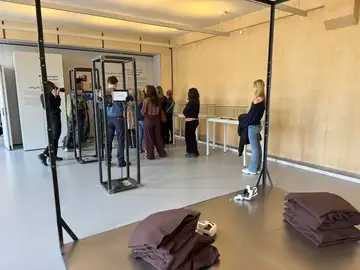 Visitors moving through the Sednaya exhibition and its testimony installations in Berlin
