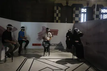 Visitors using virtual-reality headsets at the Syria Prisons Museum launch in Damascus